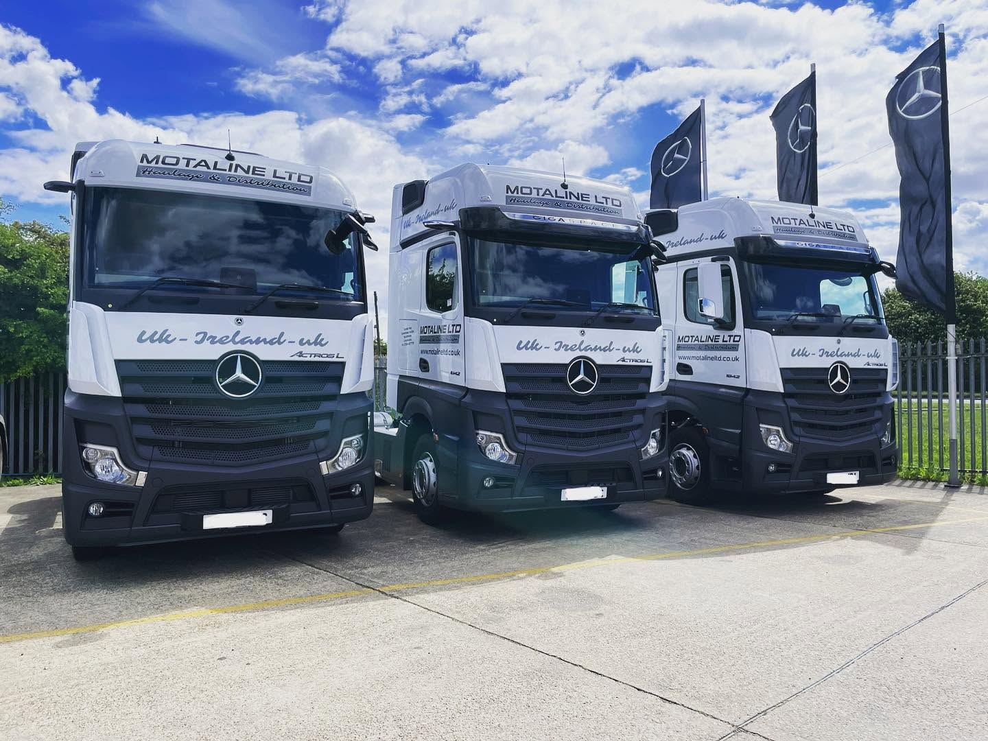 Line of clean commercial trucks prepared on a dealership site