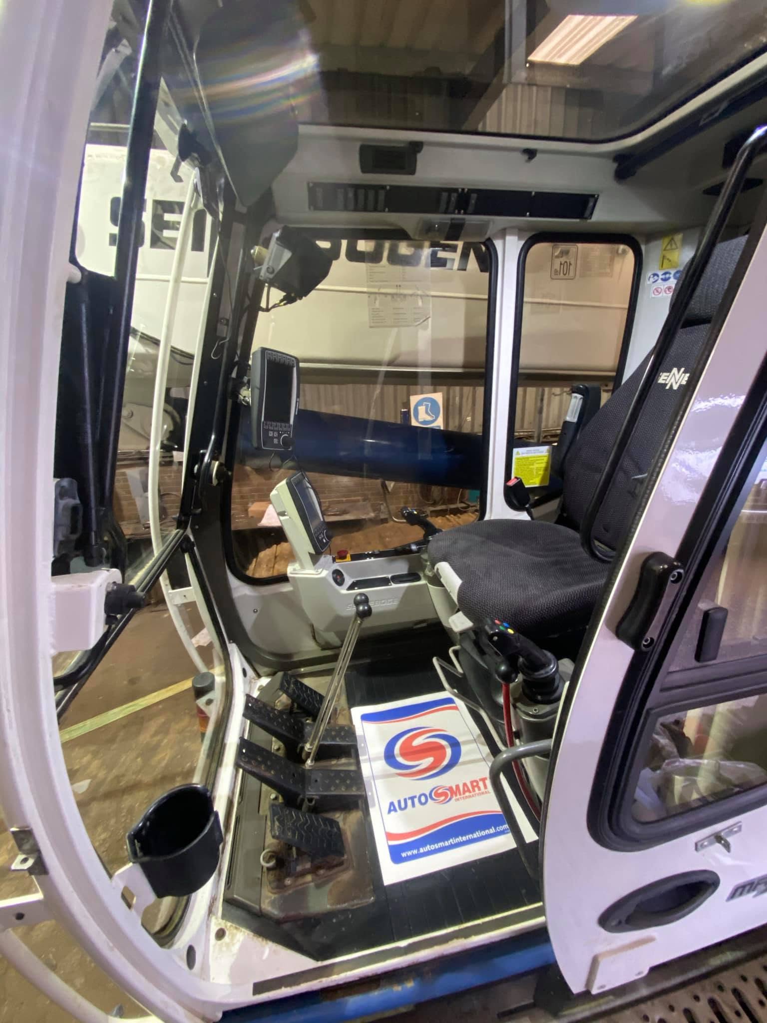 Clean plant machinery cab interior with controls and seat visible